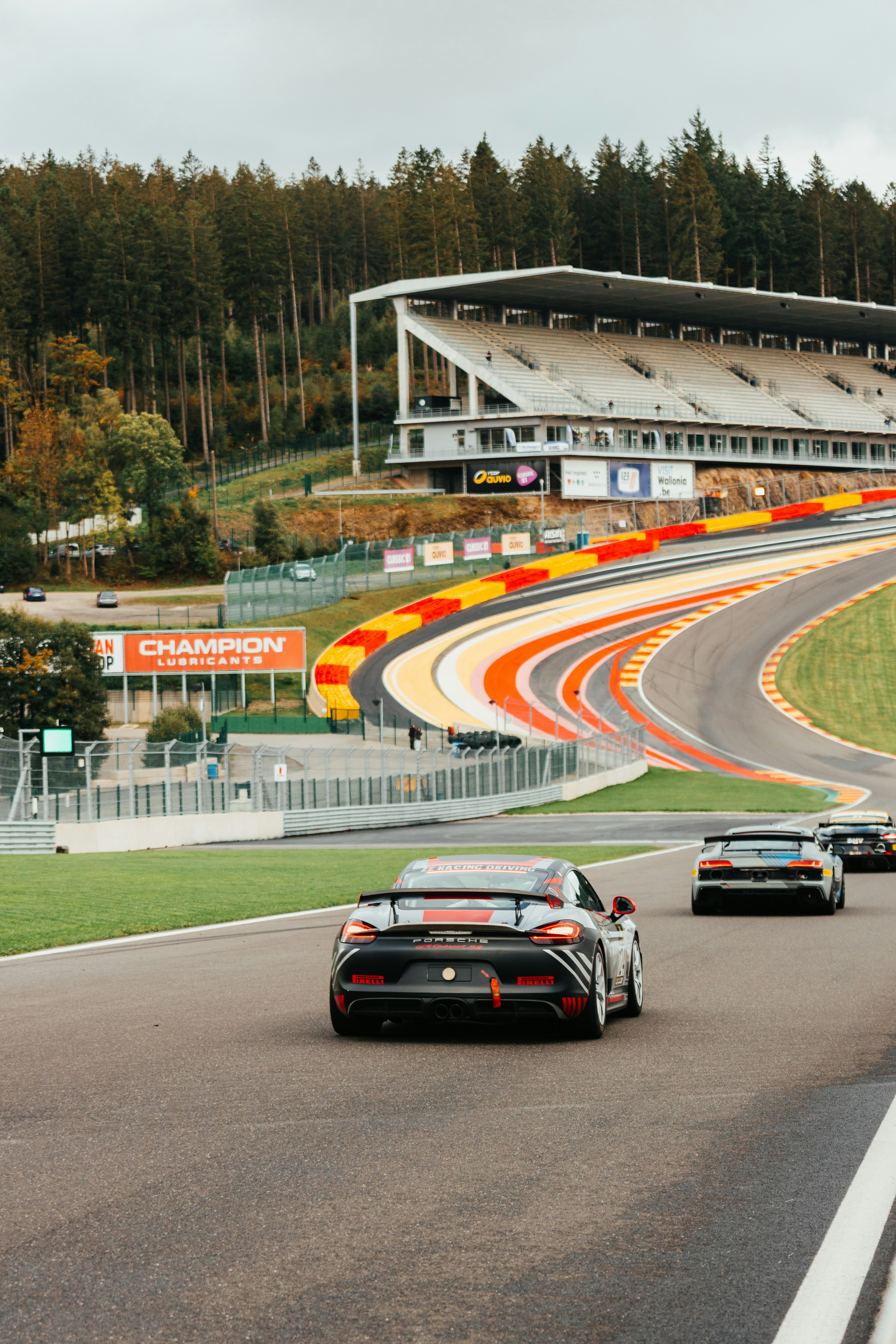 Rennwagen, die auf einer Strecke mit Tribünen rasen.