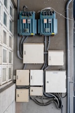 Electrical boxes and transformers mounted on a wall.