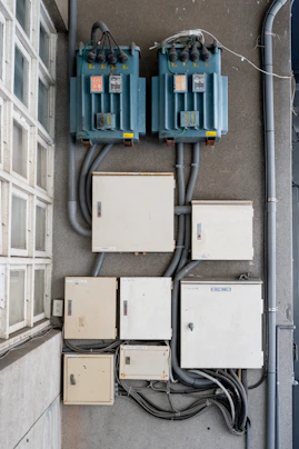 Electrical boxes and transformers mounted on a wall.