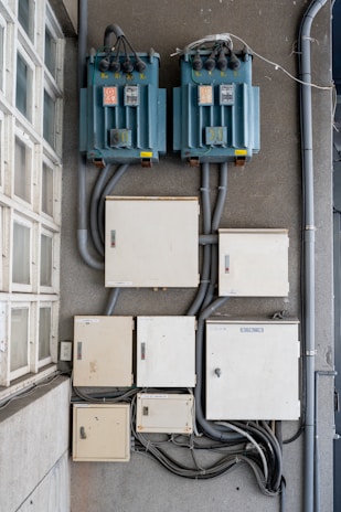 Electrical boxes and transformers mounted on a wall.