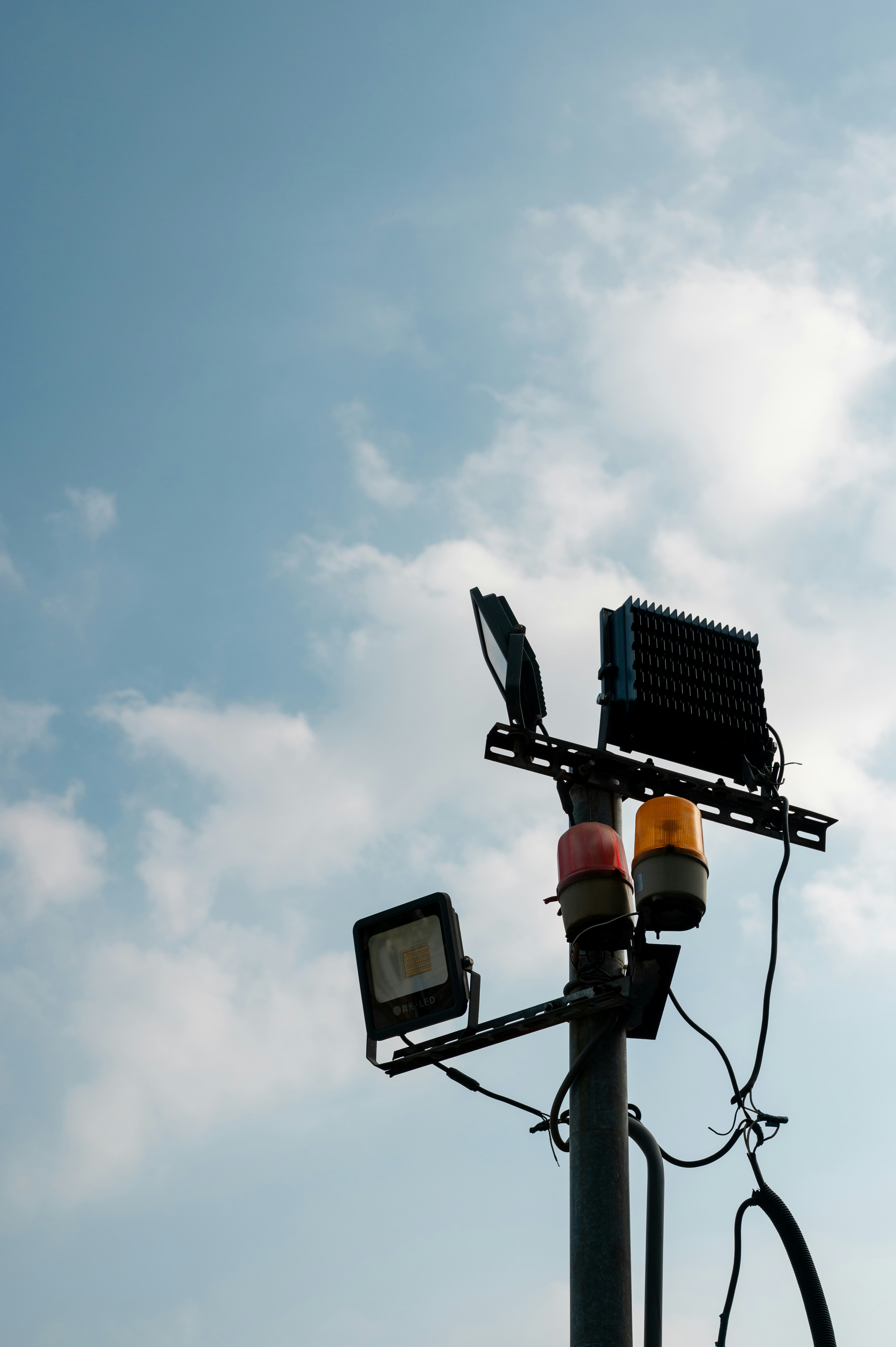 Streetlights and warning lights against a cloudy sky