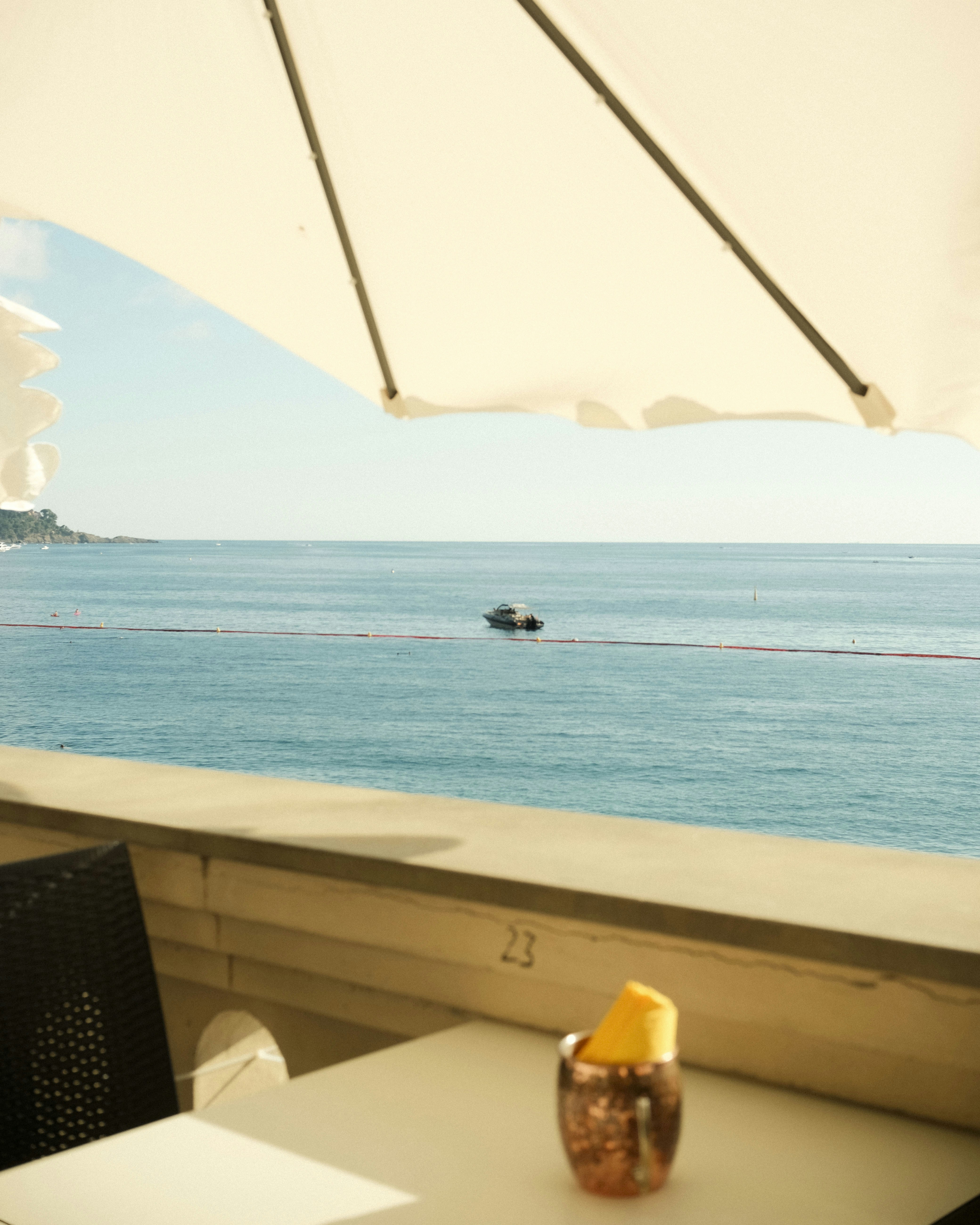 Table with umbrella overlooking calm blue ocean