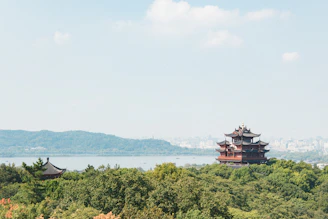 Traditional asian pagodas on a lush green hill.