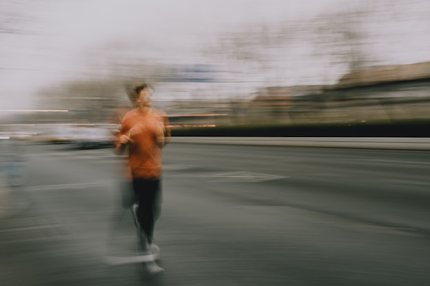 A person running on a street with motion blur.