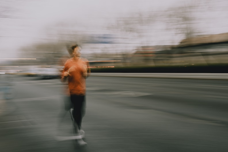 A person running on a street with motion blur.