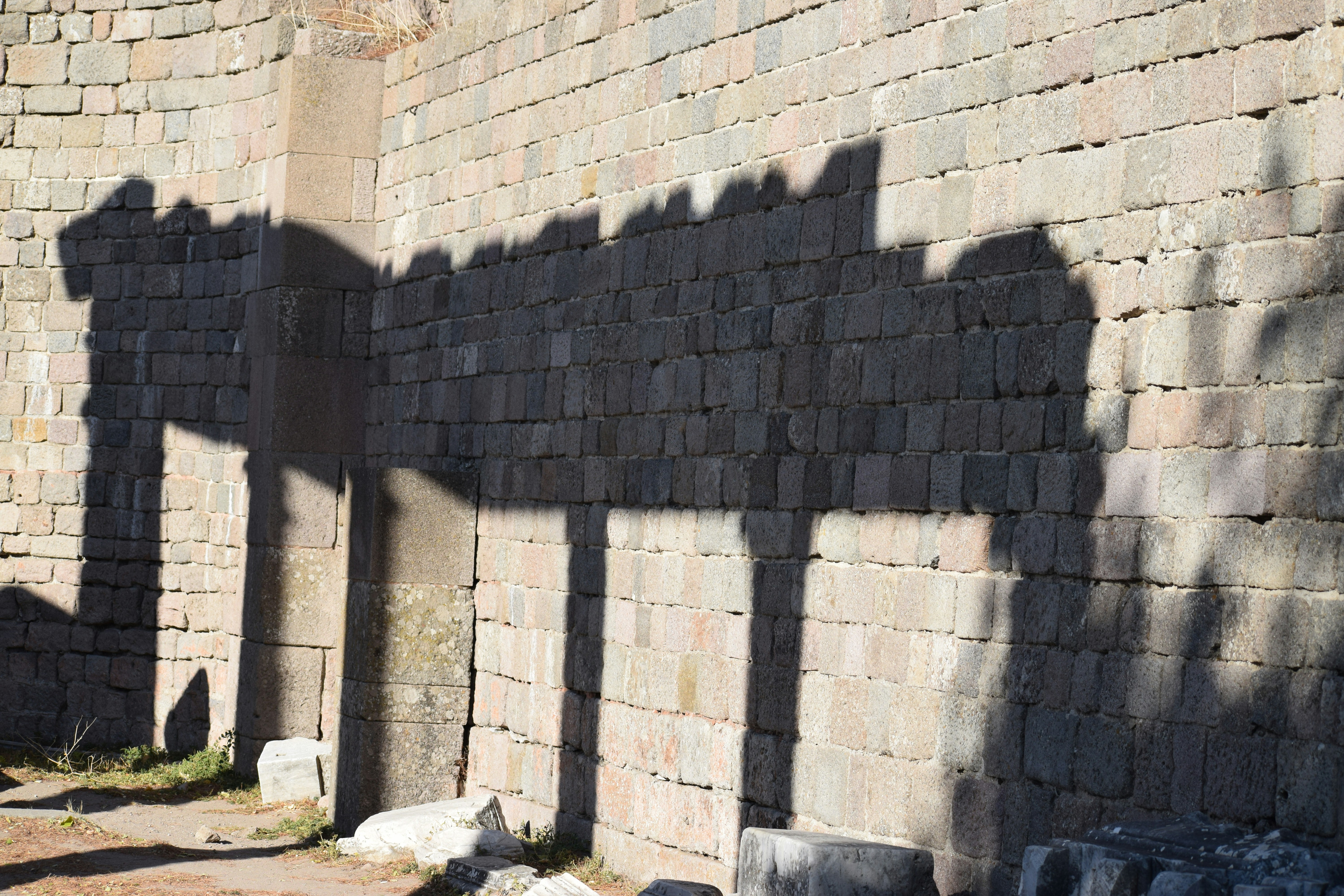Shadows of columns on a stone wall