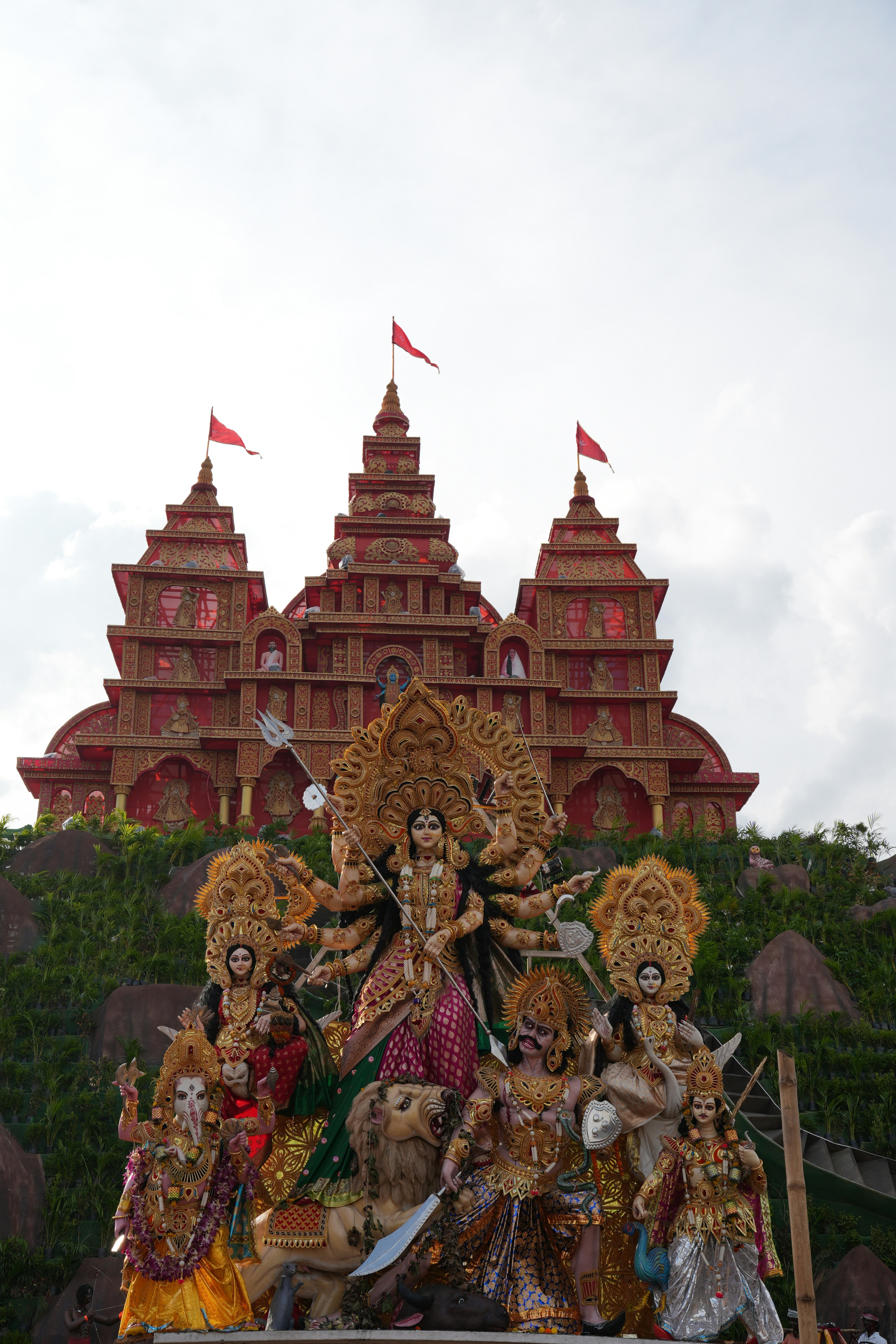 Elaborate hindu deities displayed before a grand temple structure.