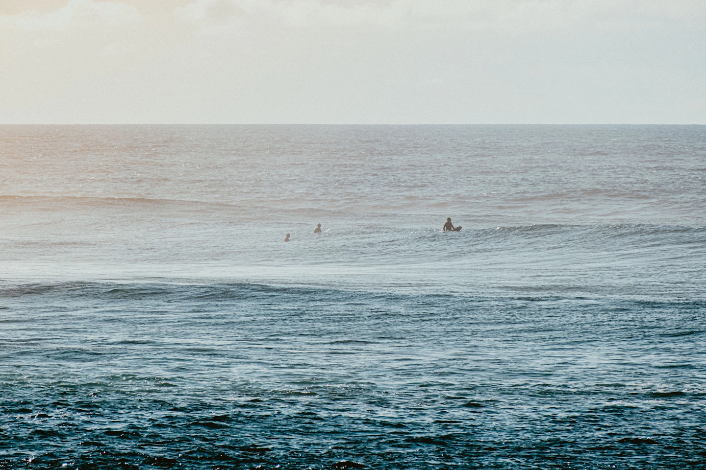 Surfers paddling out at dawn