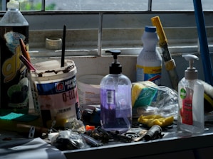 Assorted cleaning supplies and tools on a counter.