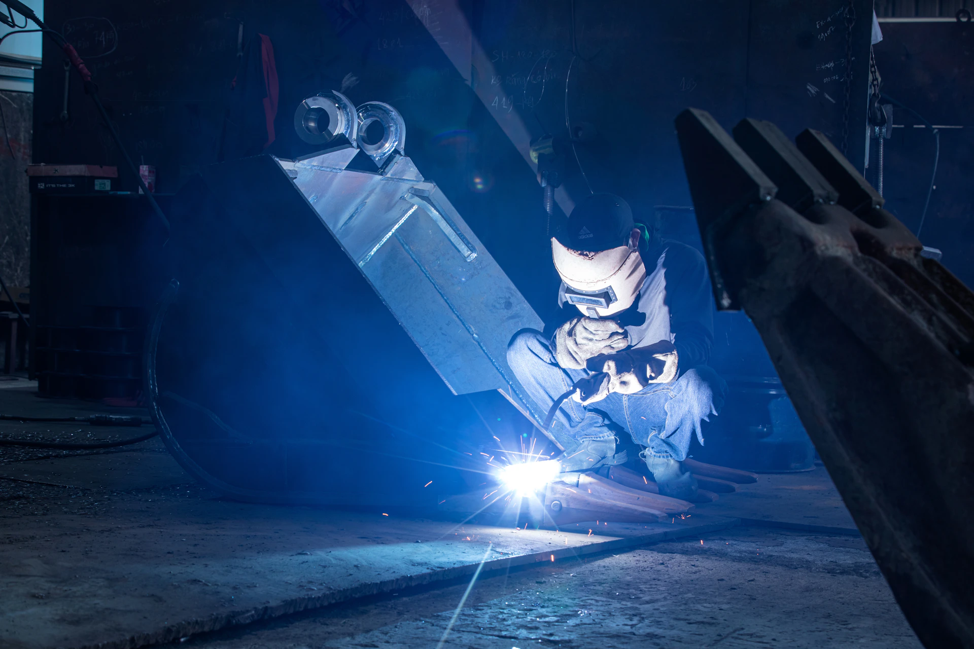 Welder working in a dark industrial setting