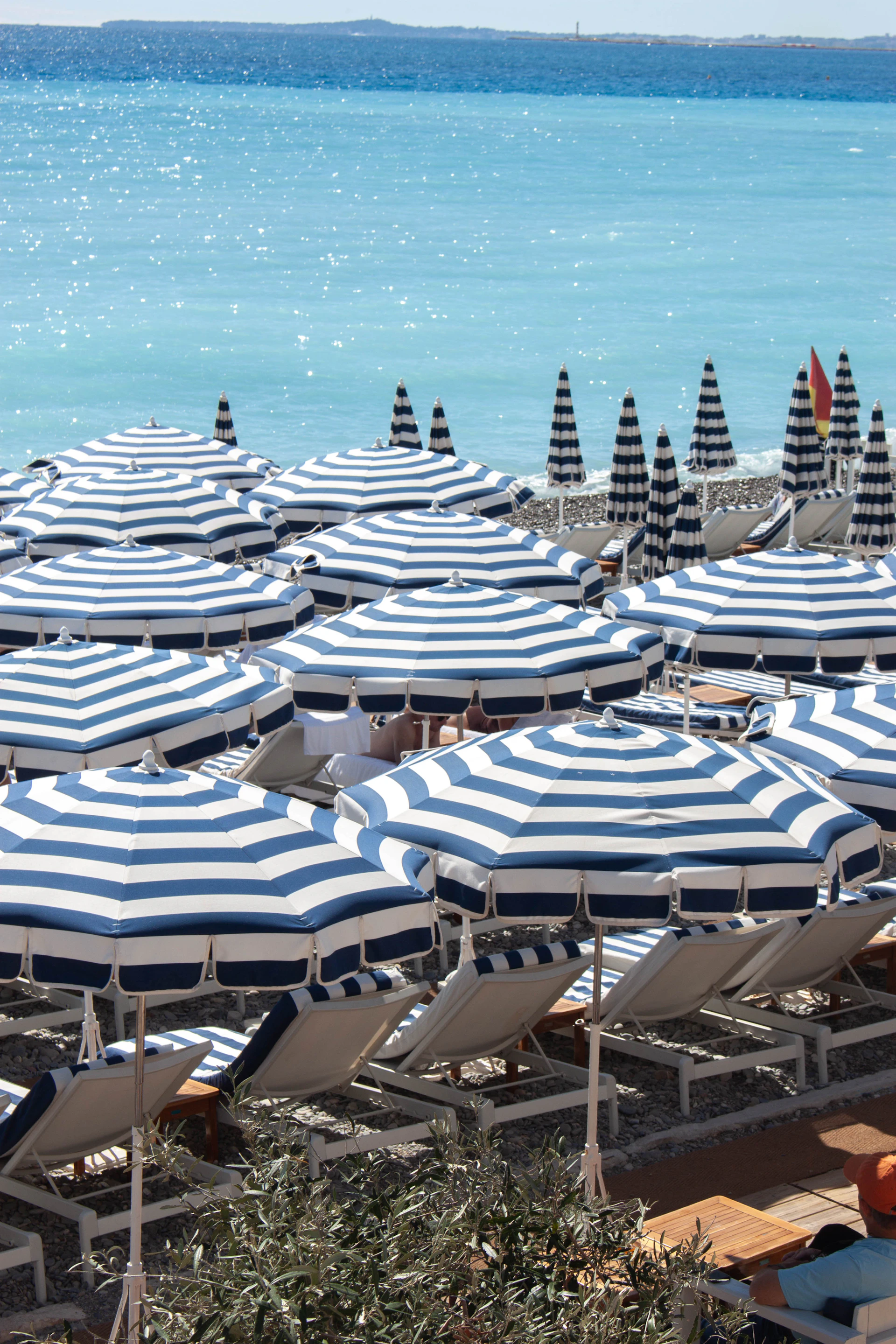 Striped umbrellas and lounge chairs on a sunny beach.
