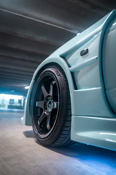 Close-up of a light blue car wheel and fender
