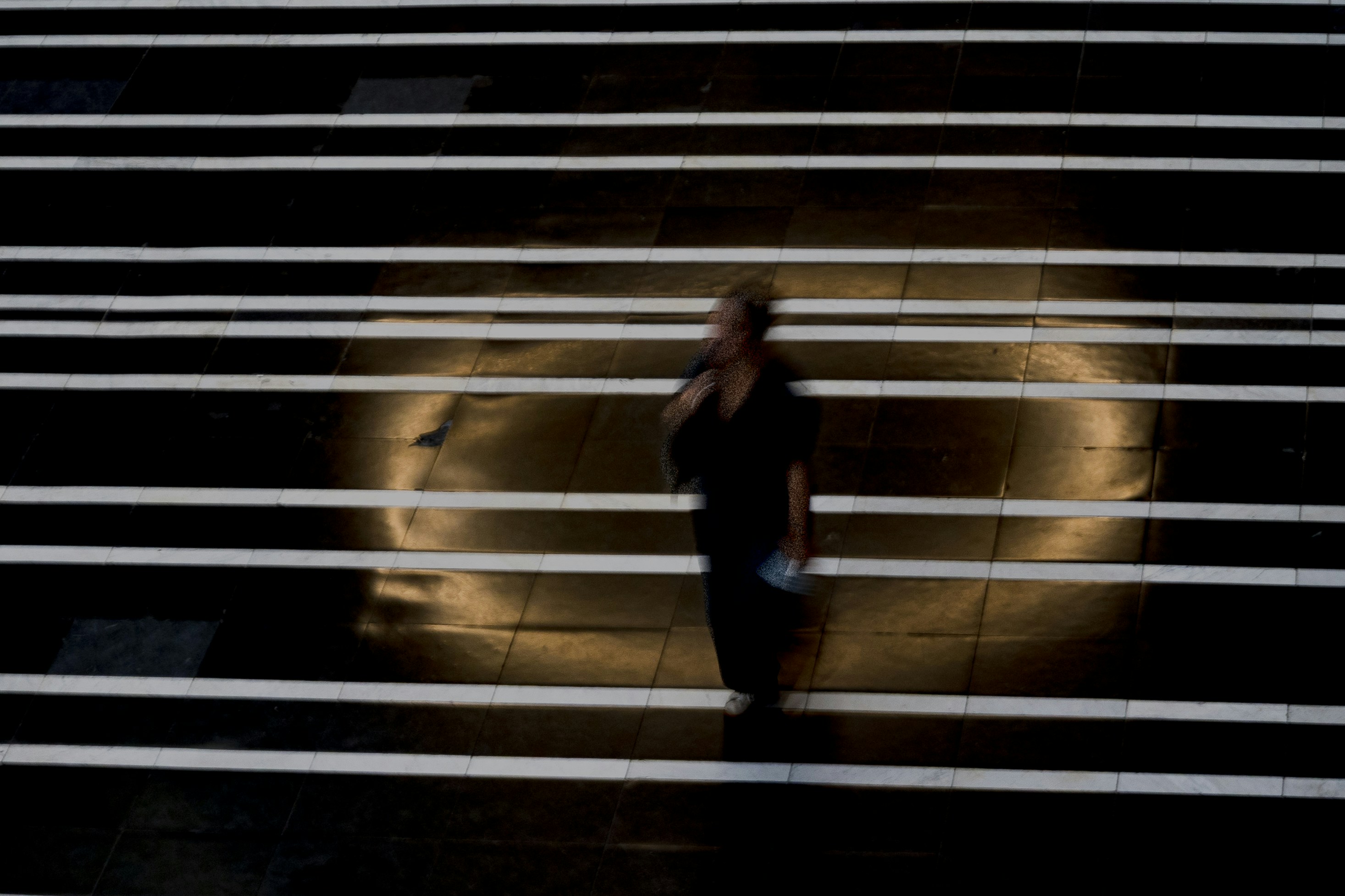 Eine Person steht auf einer Bühne mit hellem Licht.