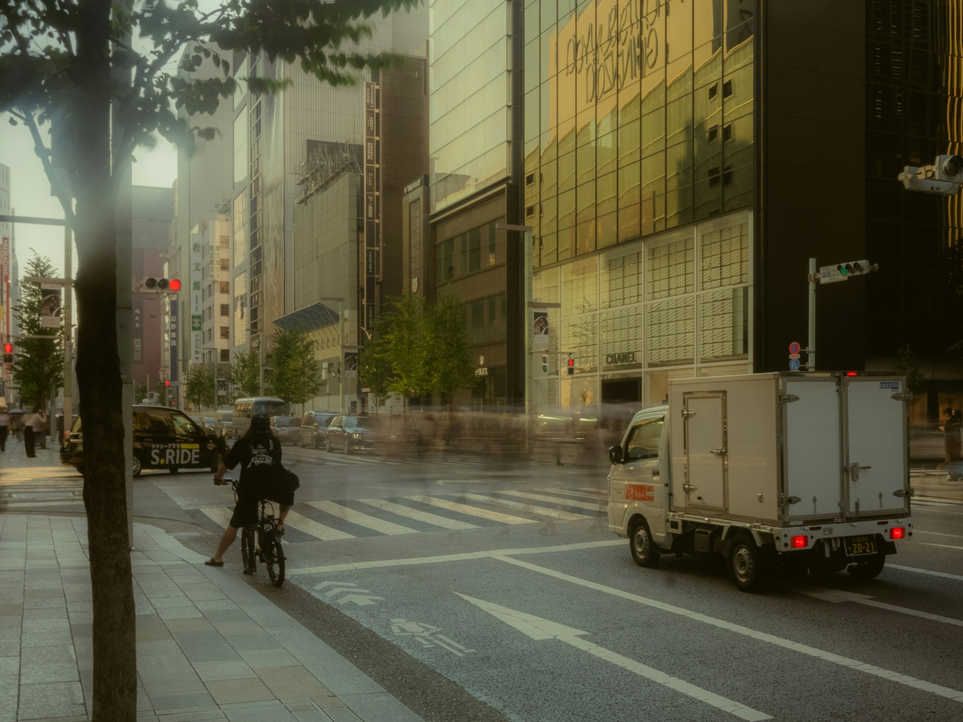City street with blurred pedestrians and a delivery truck.