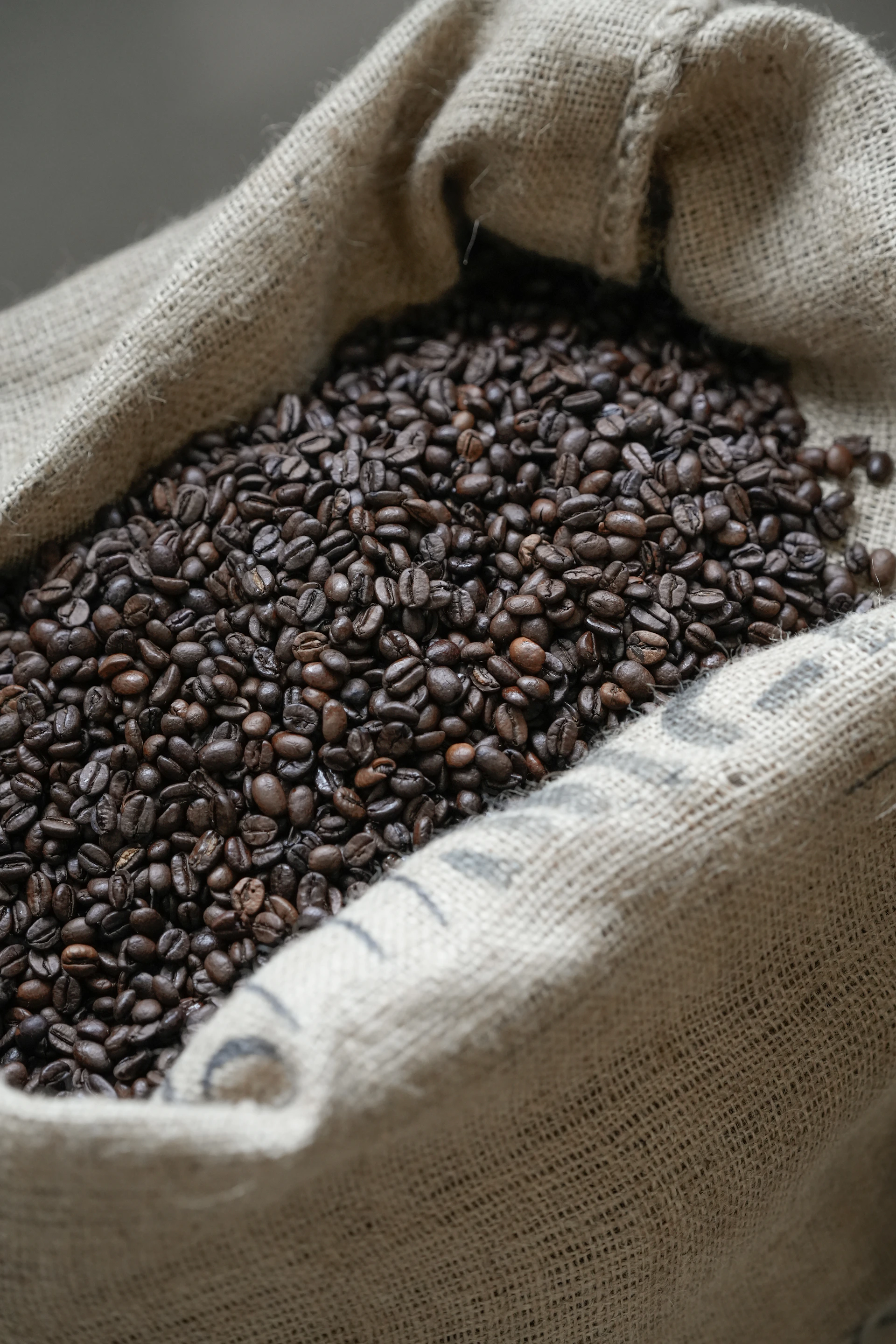 A burlap sack filled with roasted coffee beans.