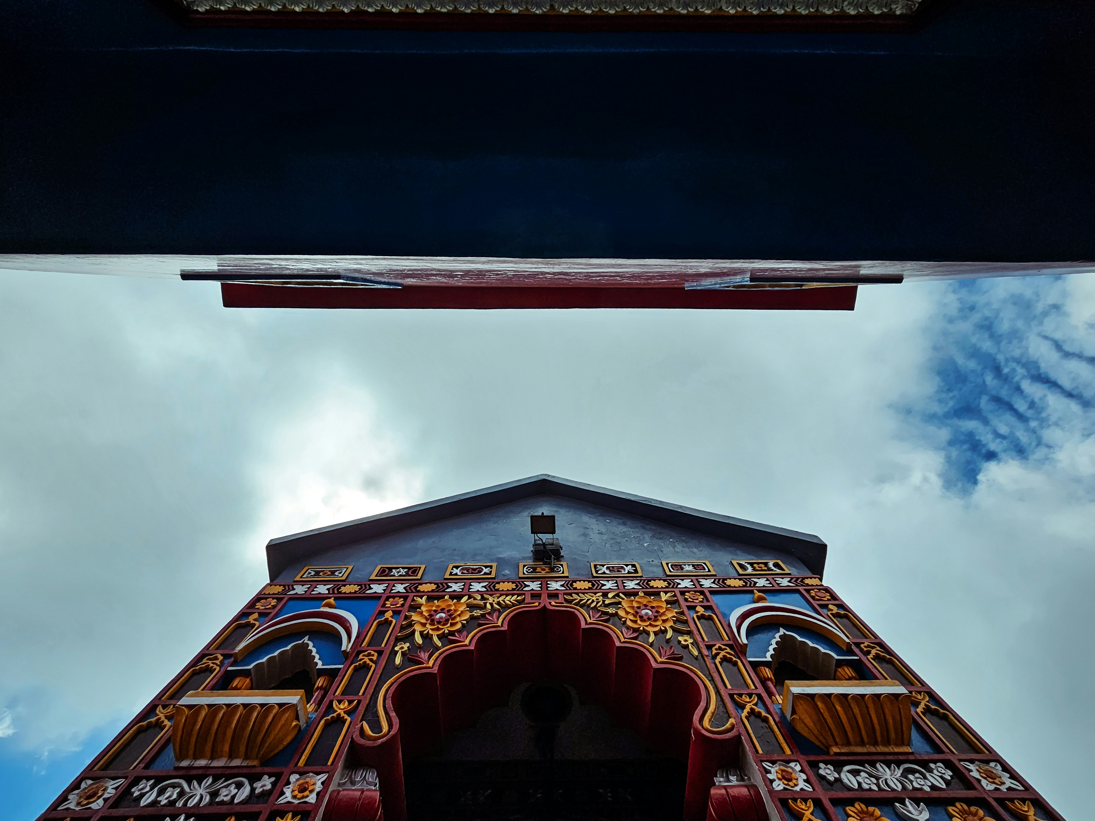 Ingresso del tempio decorato contro un cielo nuvoloso.
