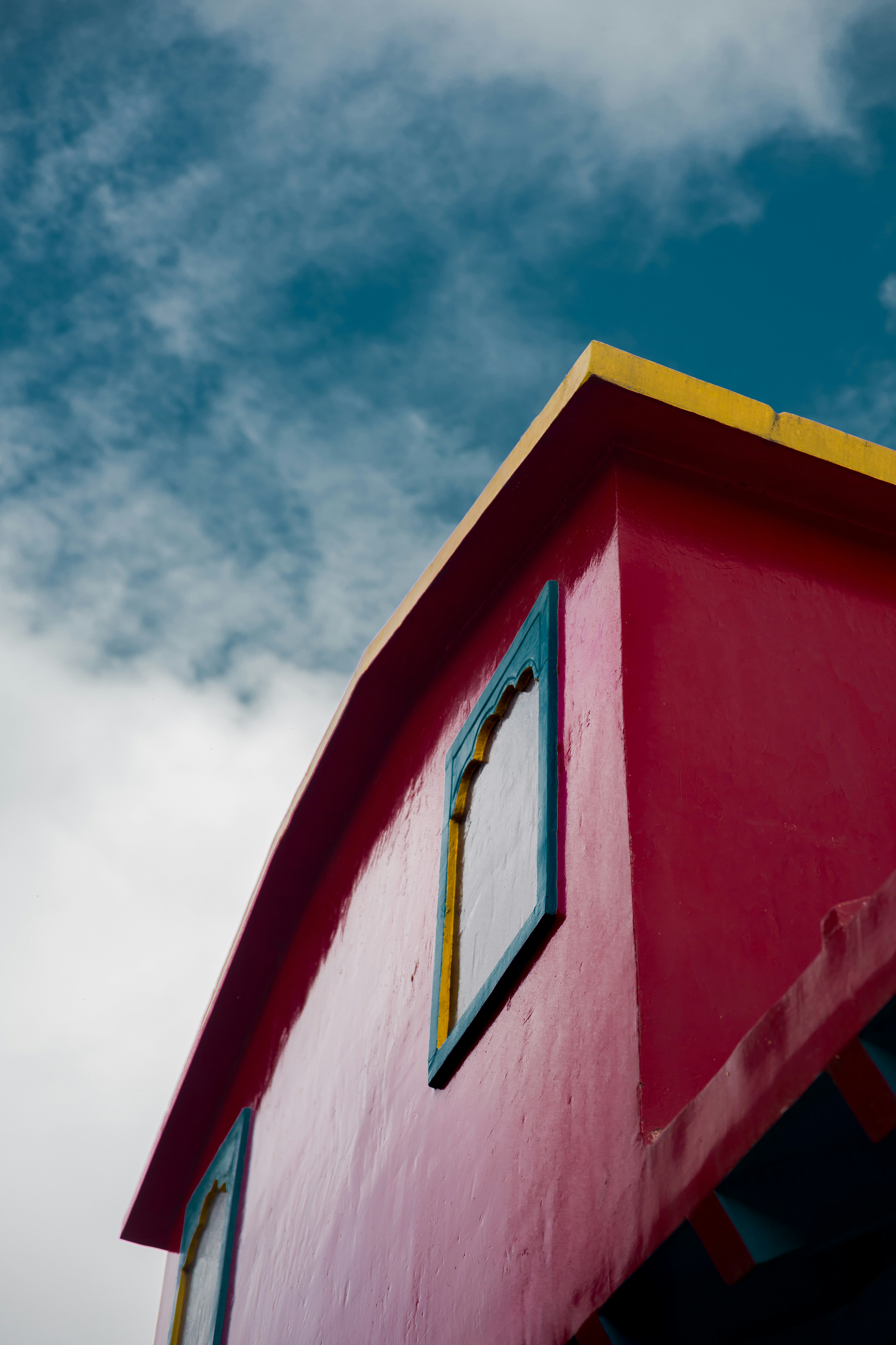 Edificio rosa brillante con finiture gialle e blu.