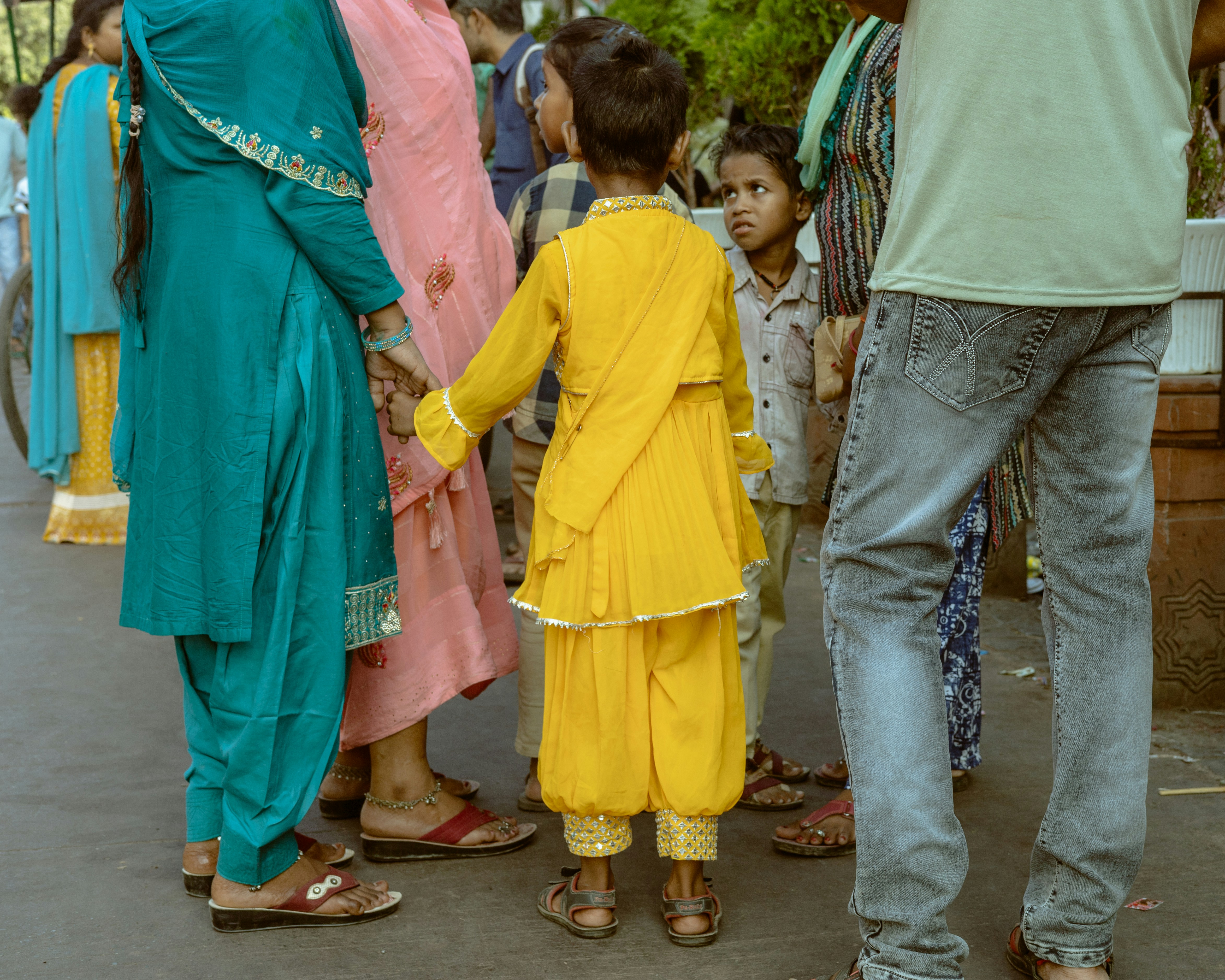 Children in colorful clothing holding hands outdoors