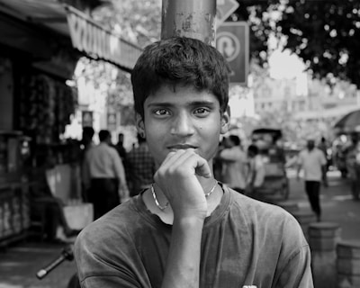 Young man with hand on chin in black and white.