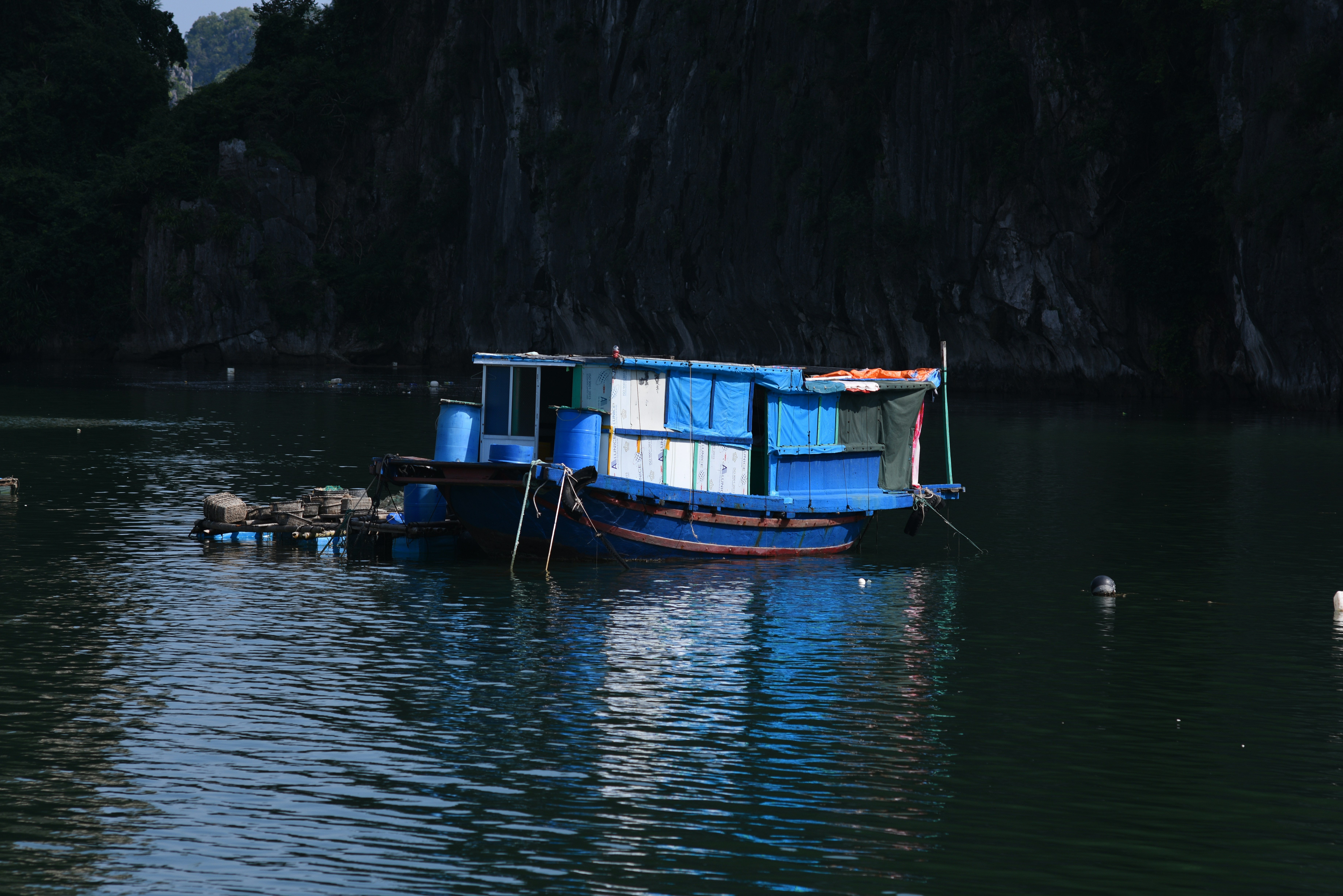 A blue floating house on dark water