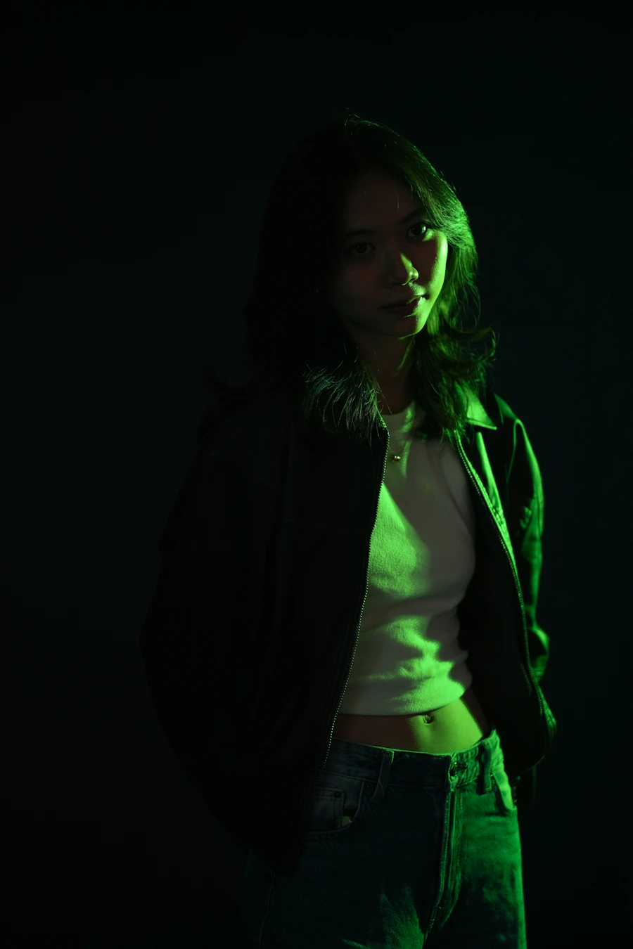 A young woman illuminated by green light