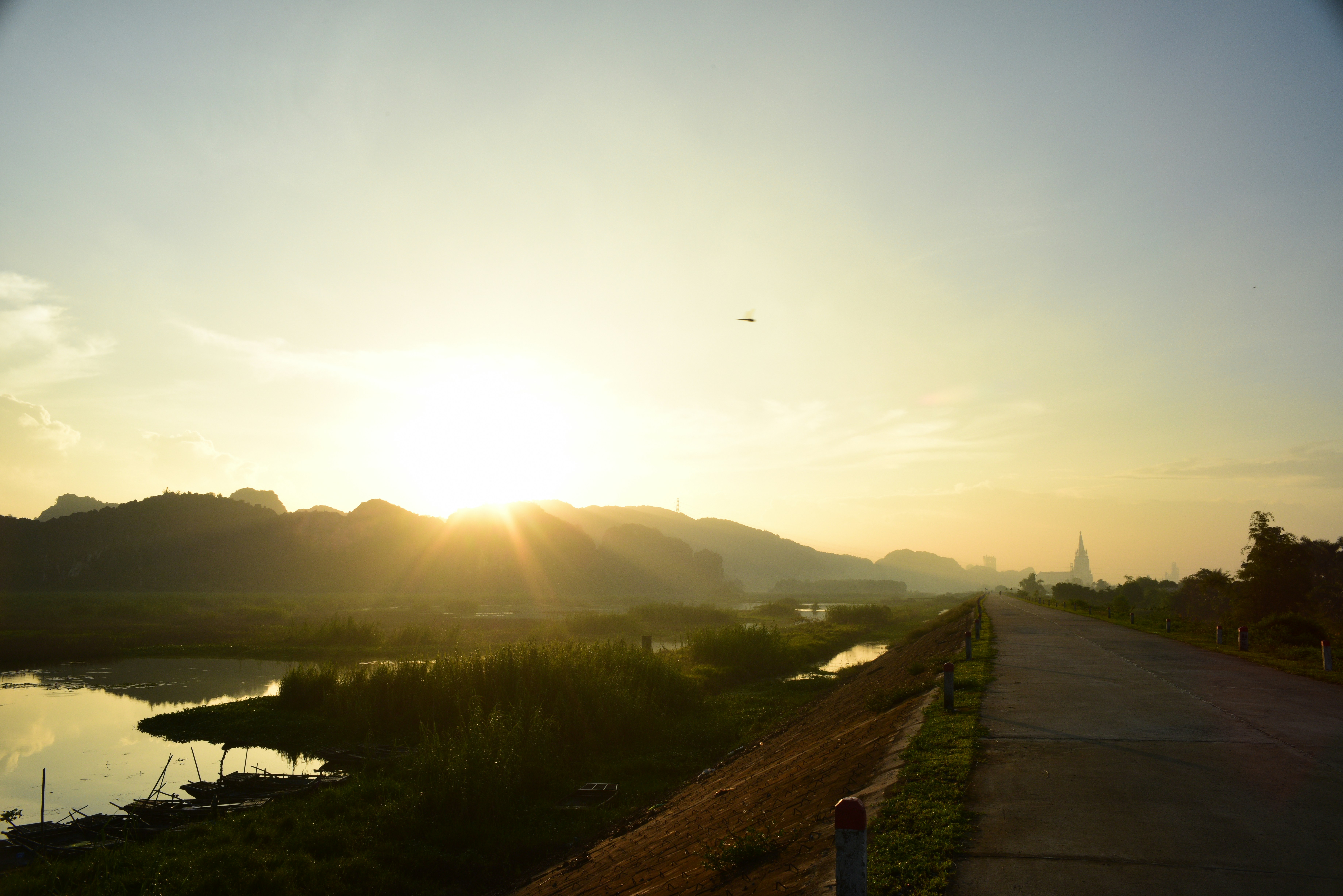 Sunrise over a tranquil landscape with a road.