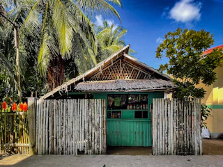 Small tropical store with bamboo fence and palm trees