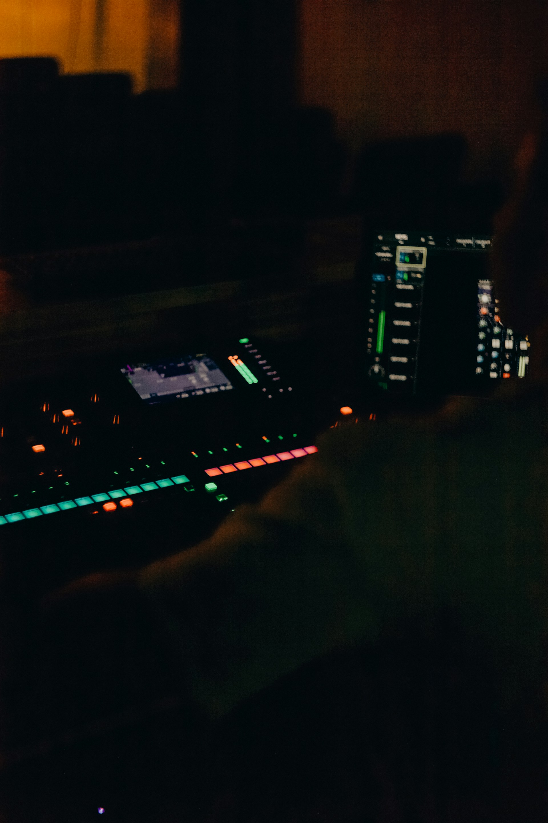 Person operating a sound mixing board at night.