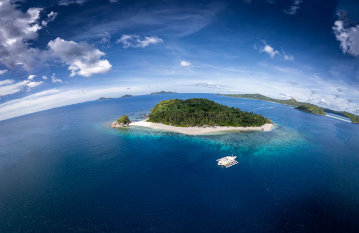 Aerial view of a small uninhabited tropical island with a boat, similar to Icacos and Palomino