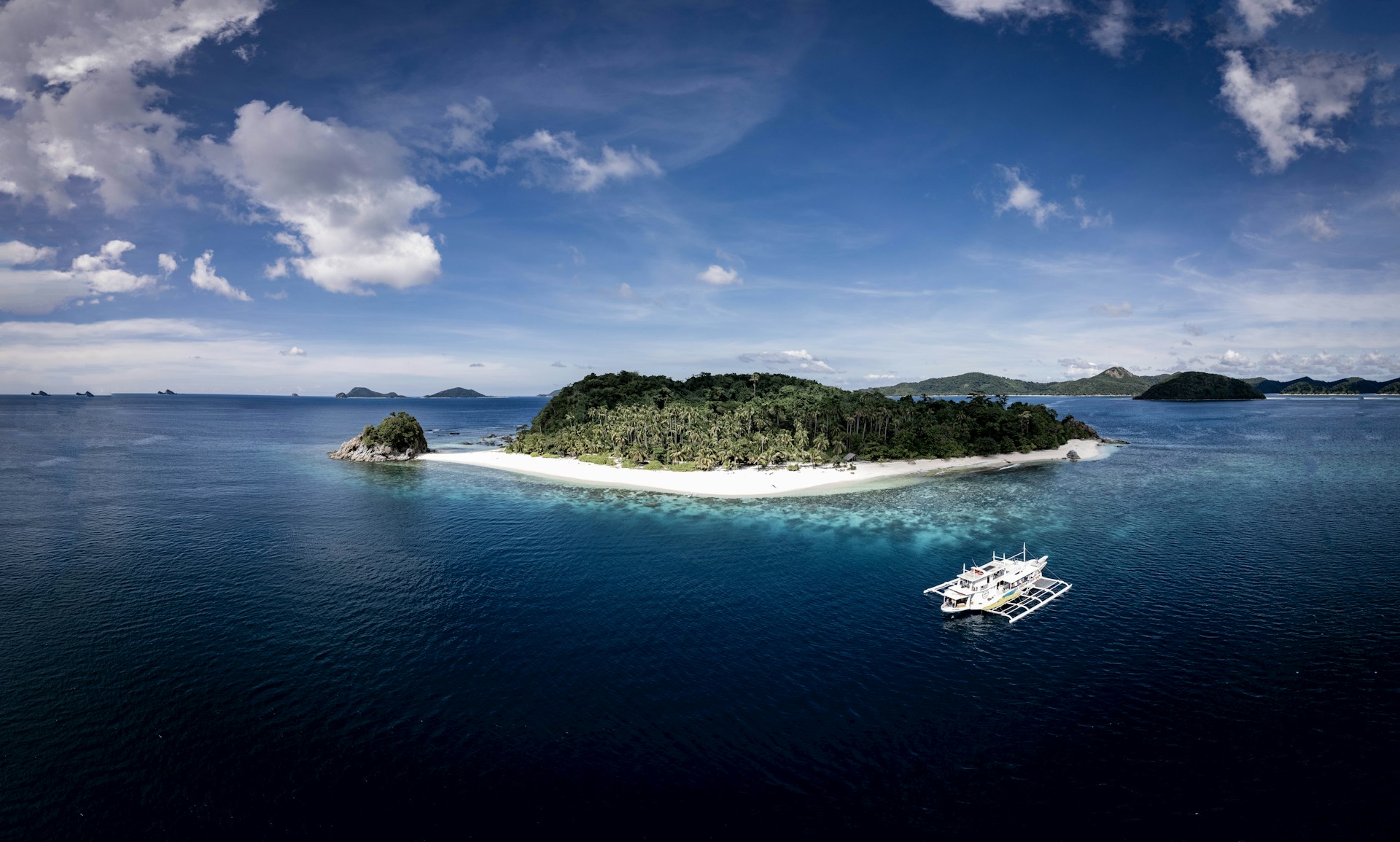 Tropical island with white sand beach and boat.