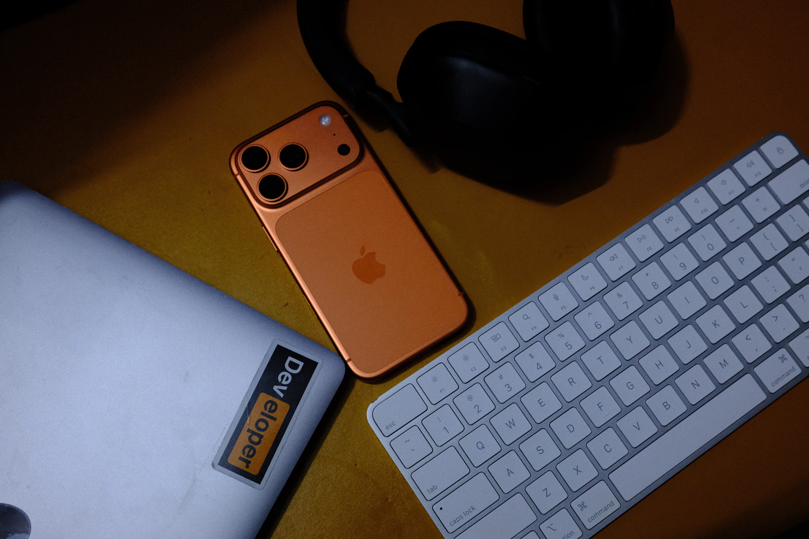 Modern smartphone, laptop, keyboard and headphones arranged on a technology workspace