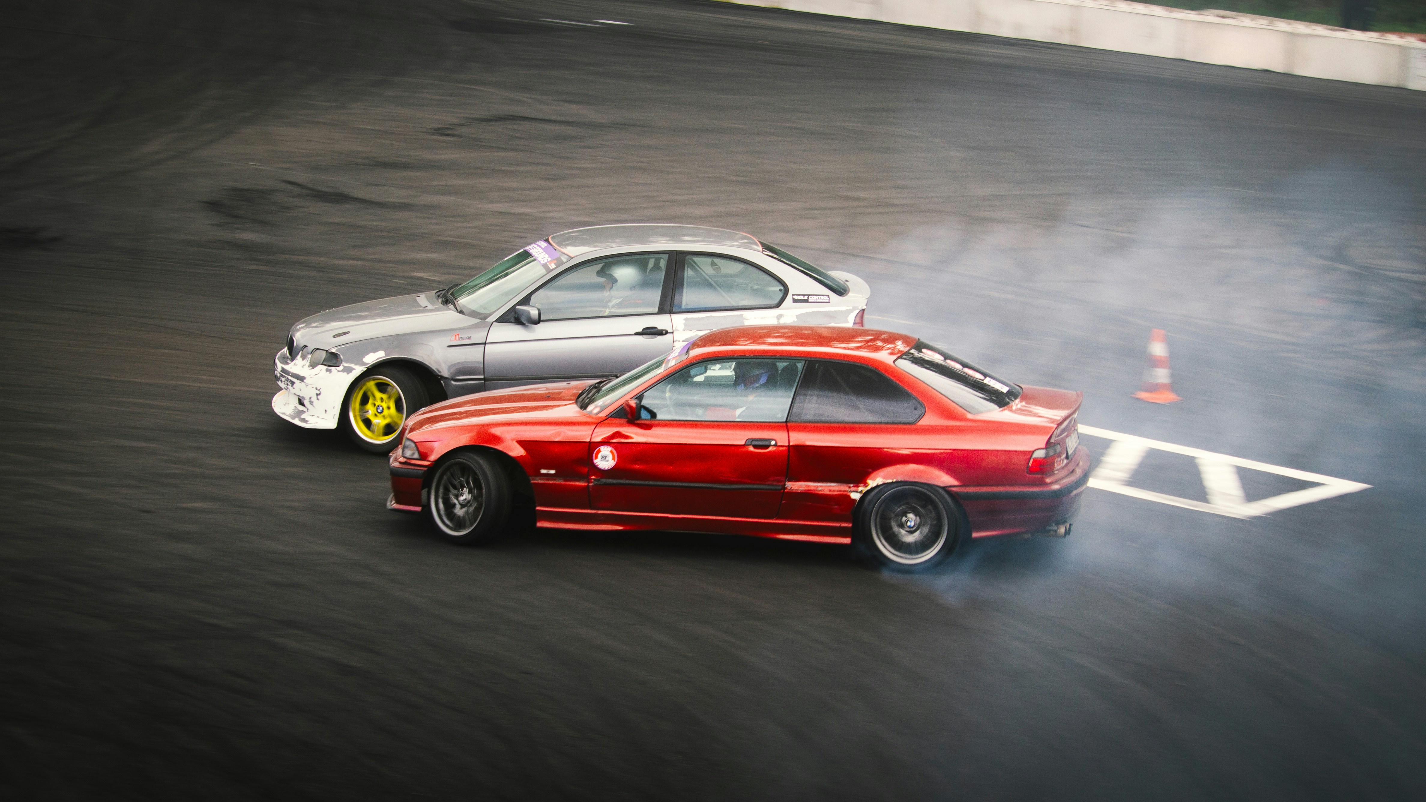 Two cars drifting on a race track
