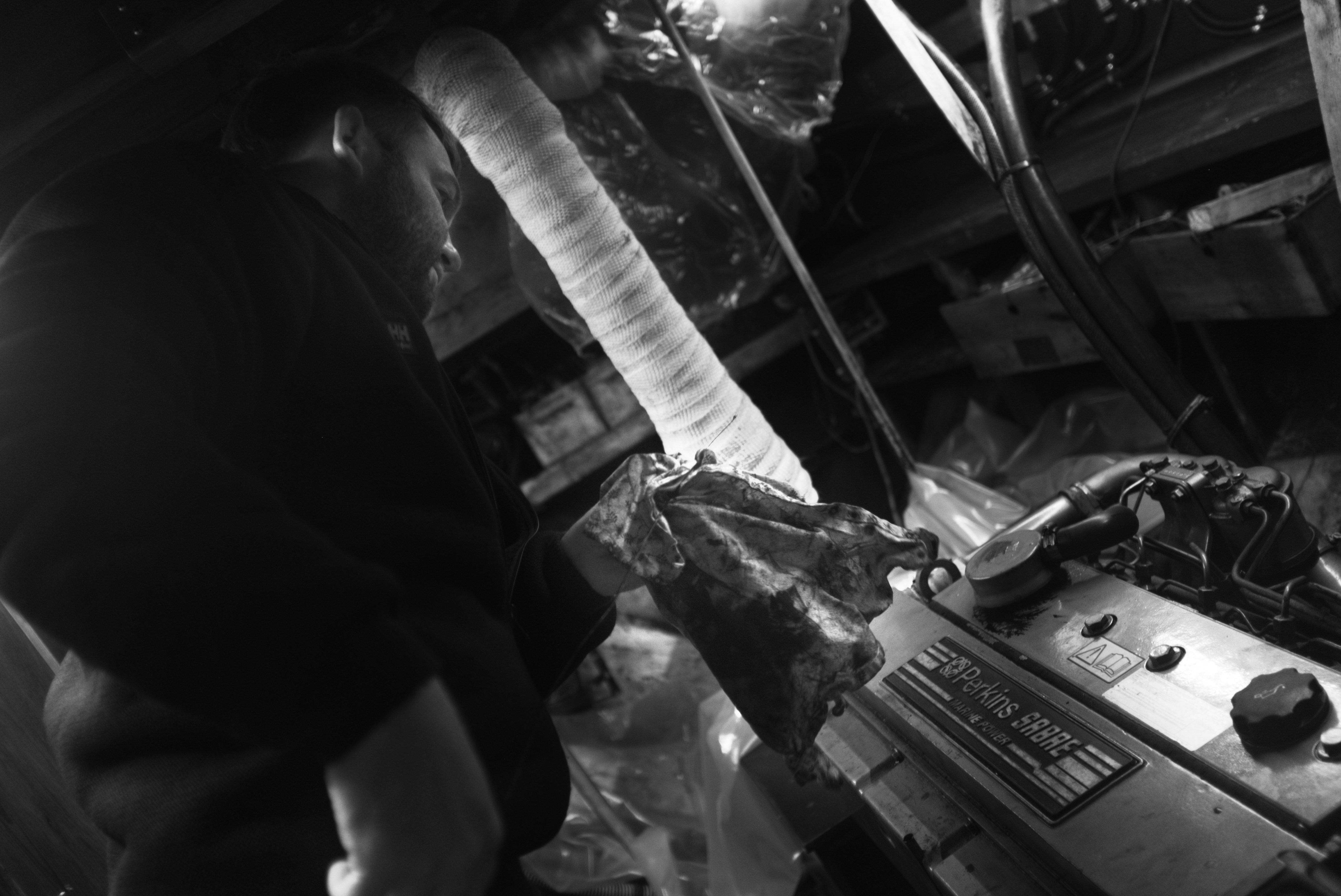 Person, die in einer schwach beleuchteten Garage am Motor arbeitet