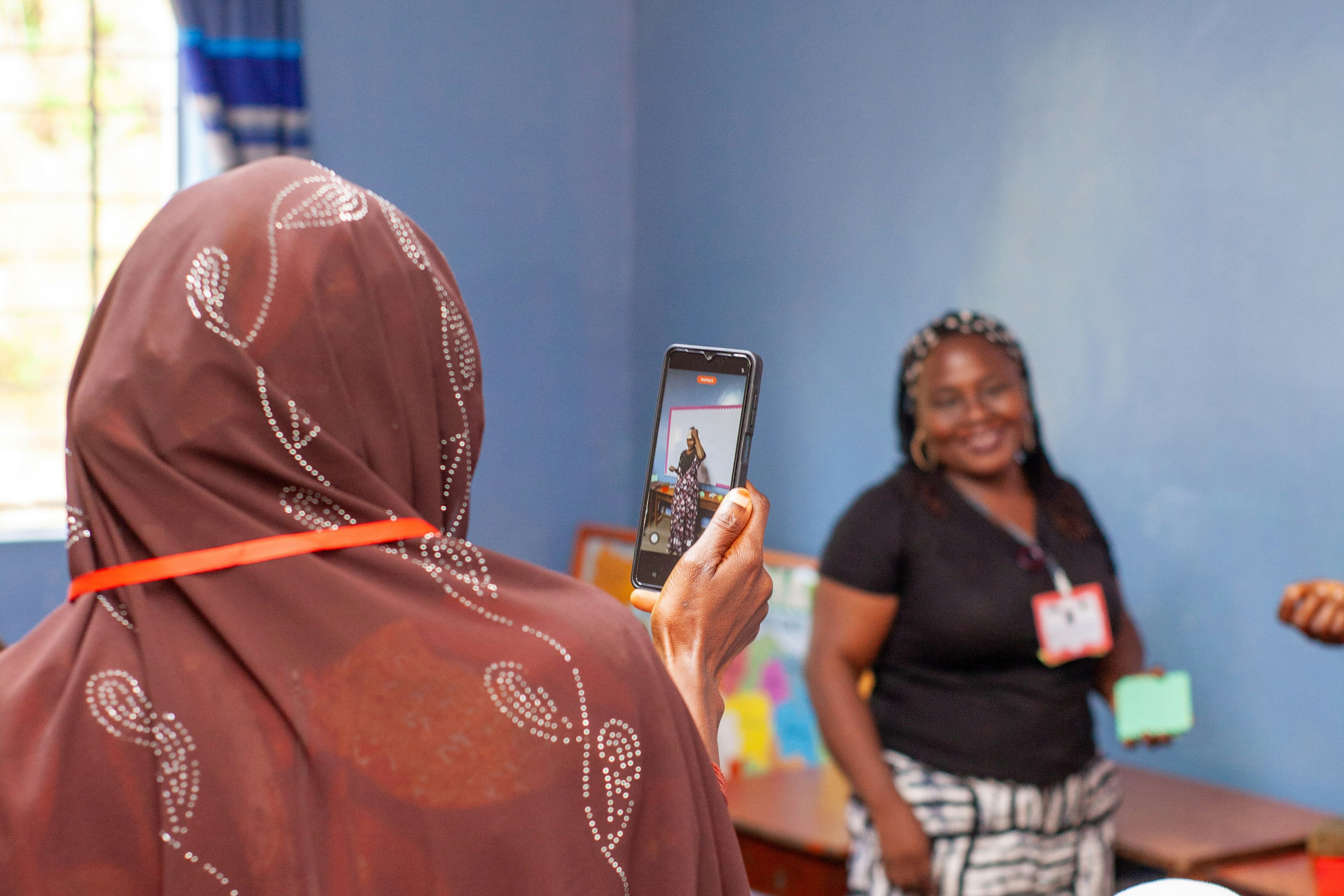 Teacher smiling while using technology