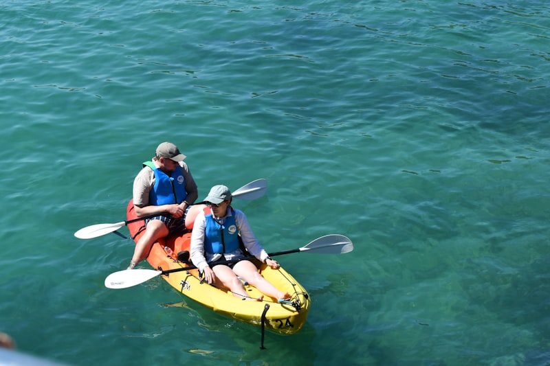Travellers kayaking across clear blue water