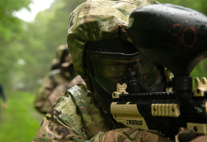 Player aiming a paintball marker outdoors