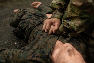 Soldier performing chest compressions on another soldier