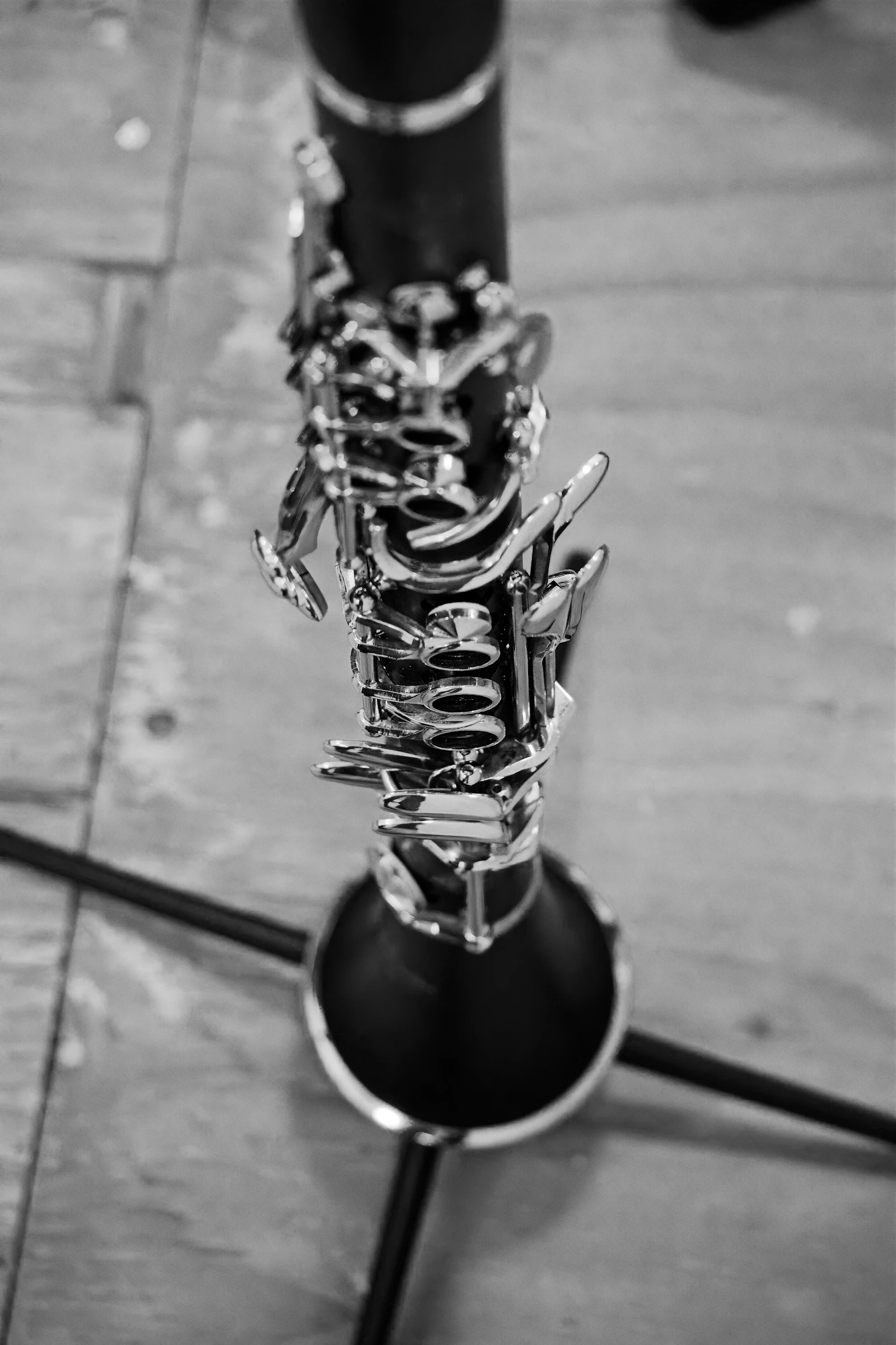 Close-up of the silver keys and black bell of an acoustic clarinet on a stand