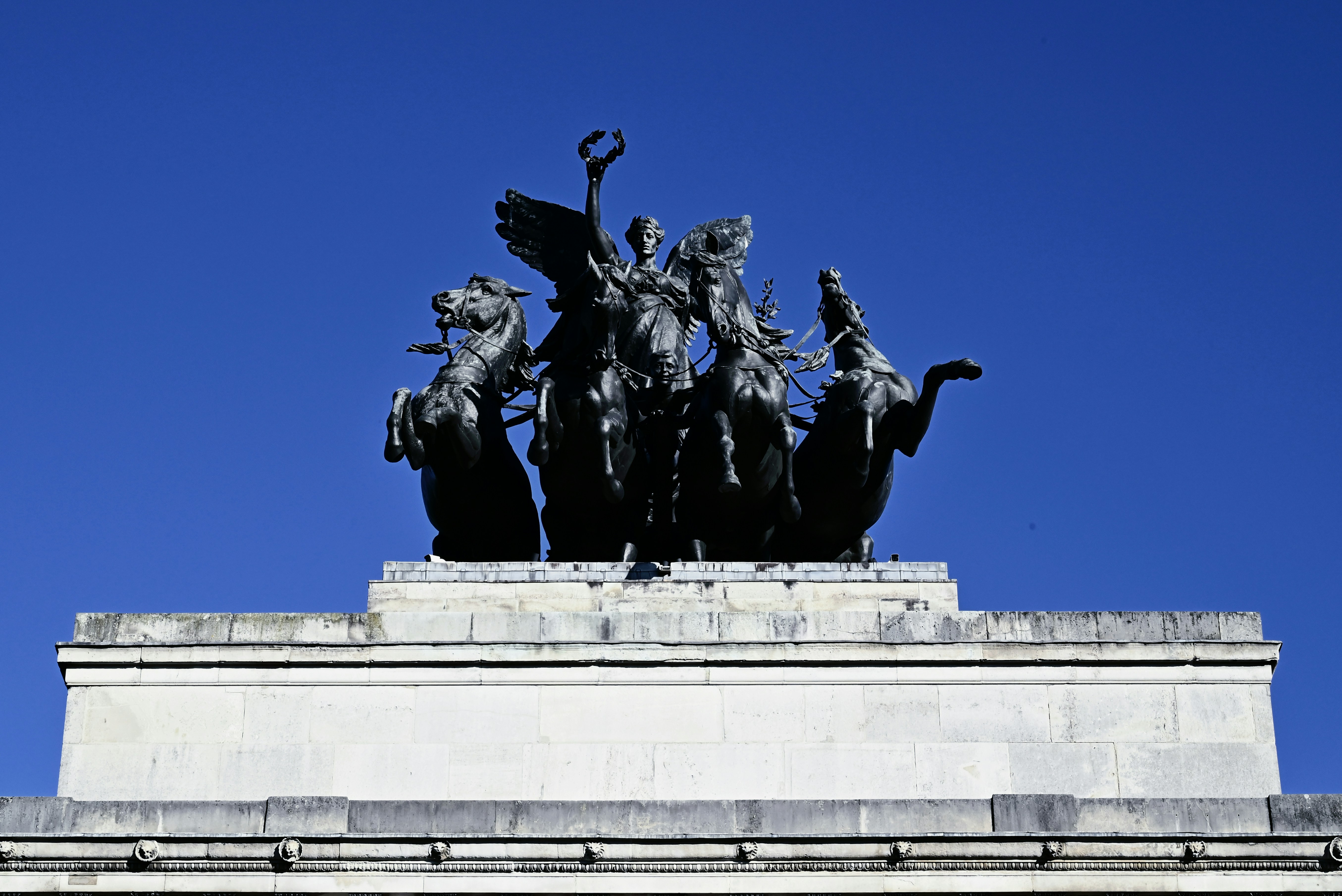 Bronze chariot sculpture atop a stone monument