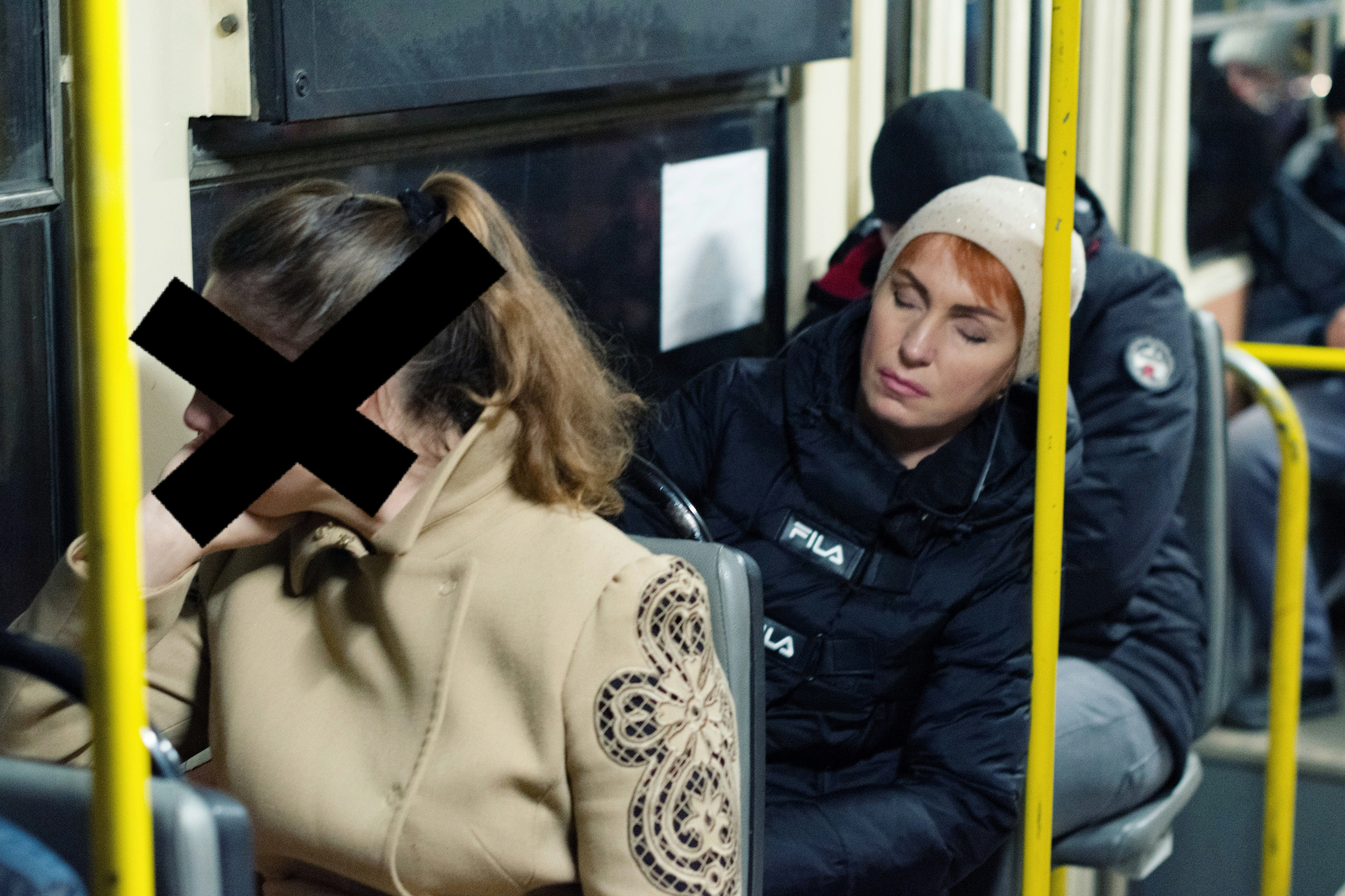 Woman sleeping on a bus next to another passenger