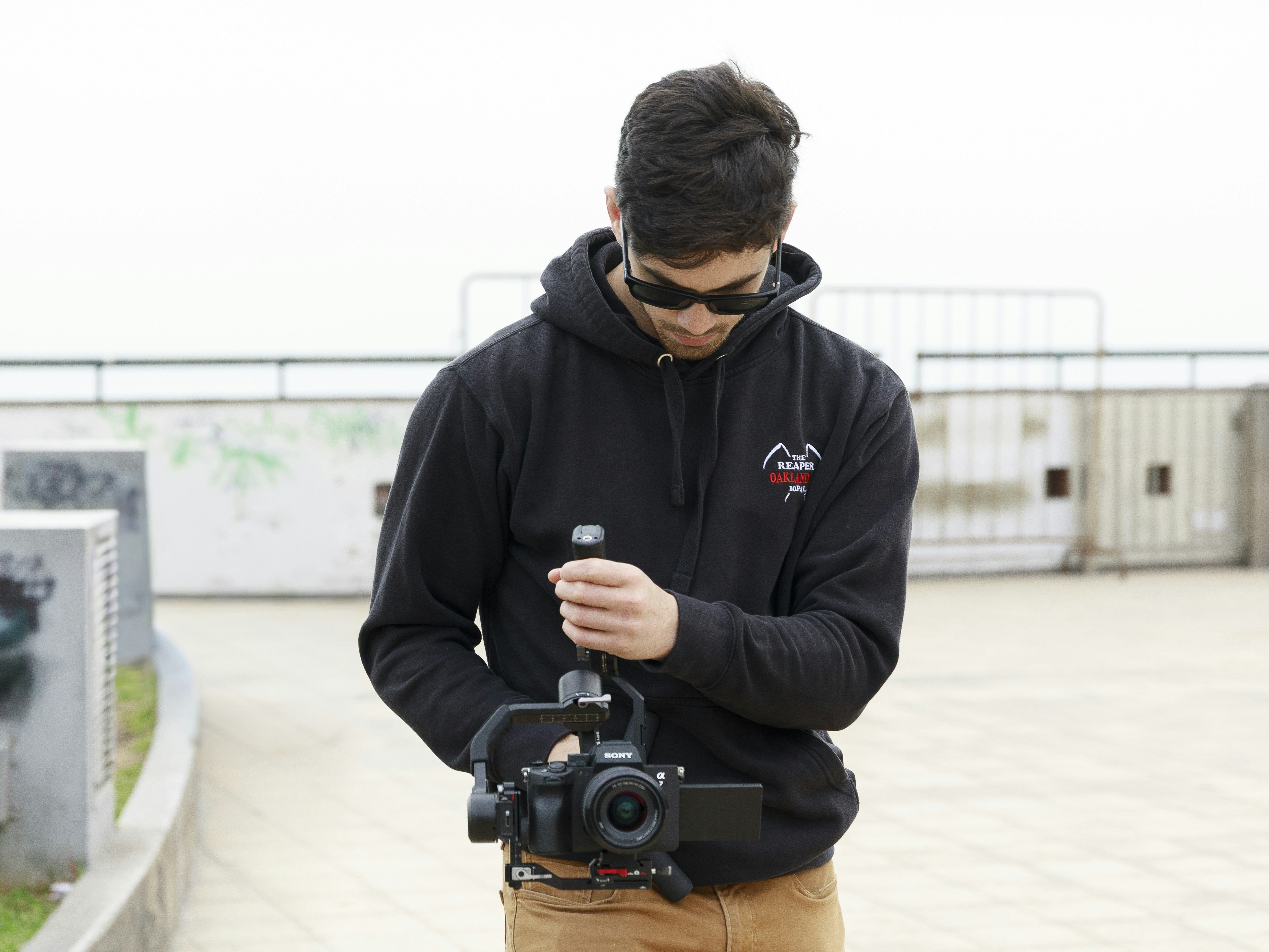 man adjusting professional video camera equipment outside