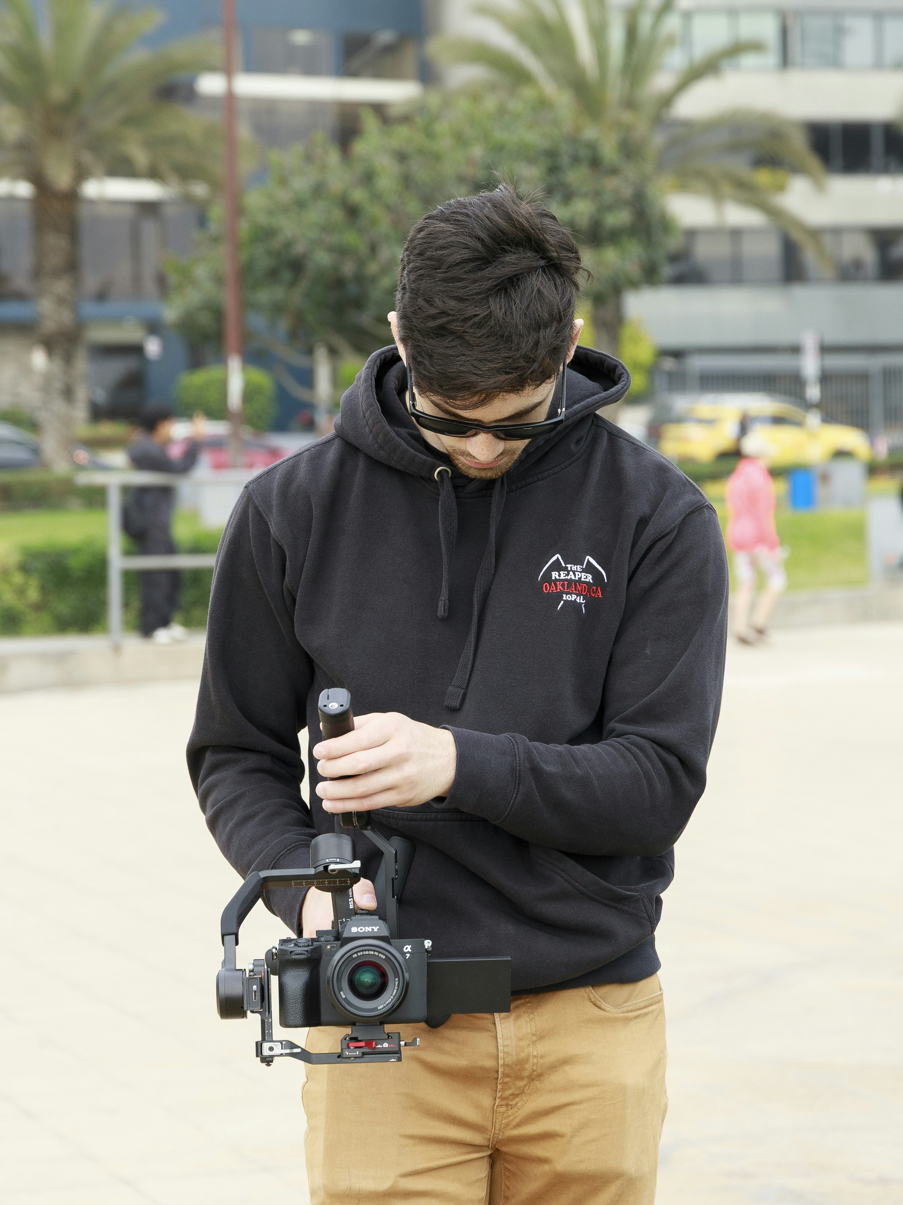 Man holding a camera stabilizer rig outdoors