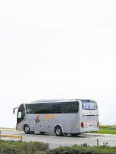 A gray tour bus parked on a road.