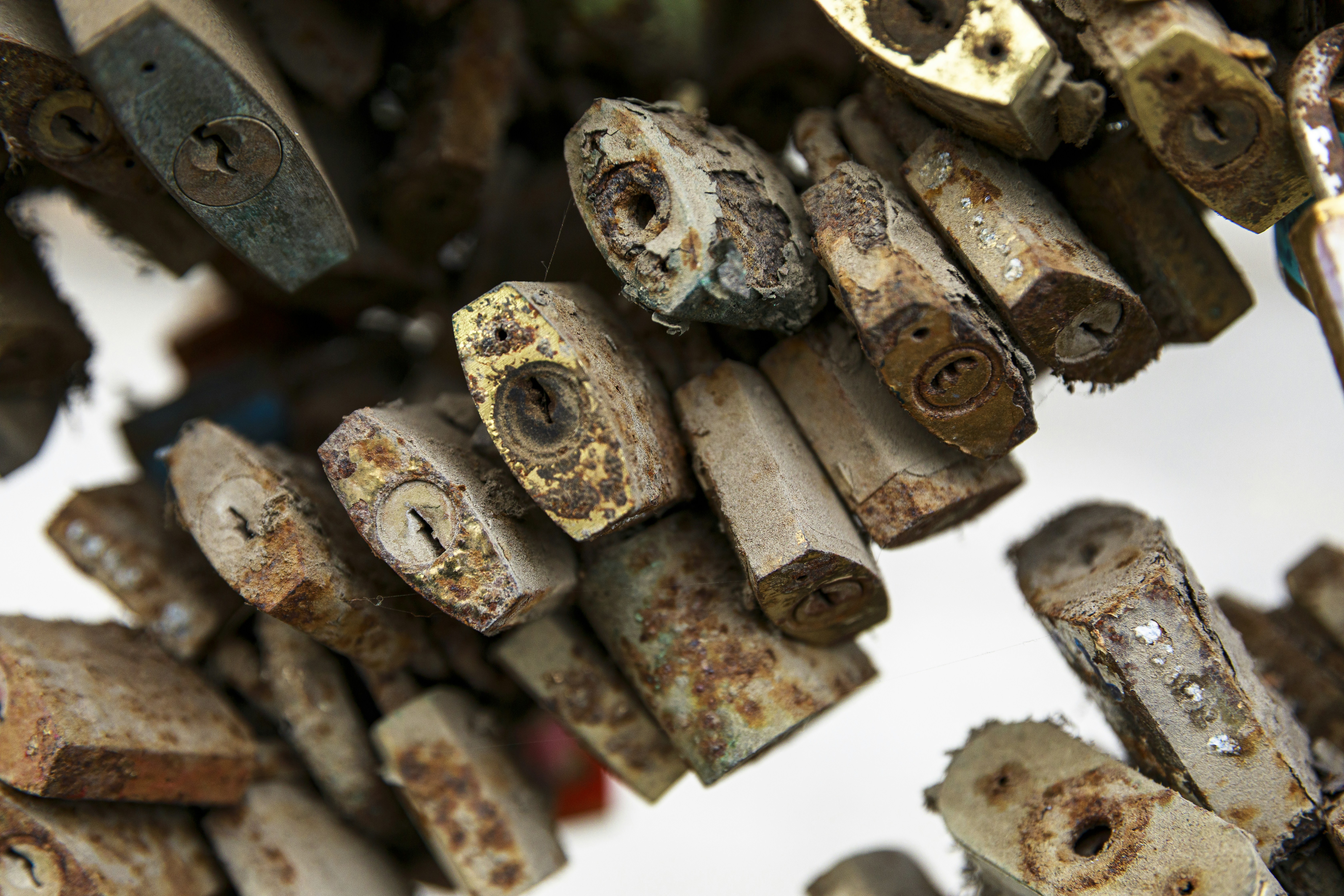 A collection of old, rusty padlocks hanging together.