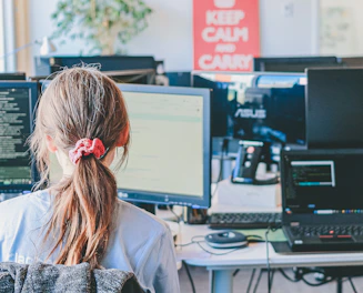 Woman working on computers in an office.