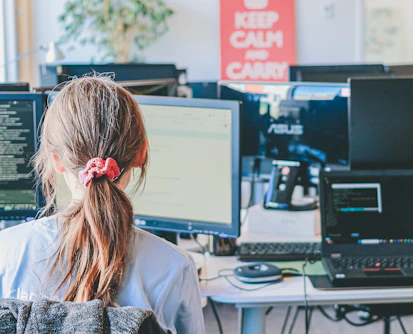 Woman working on computers in an office.