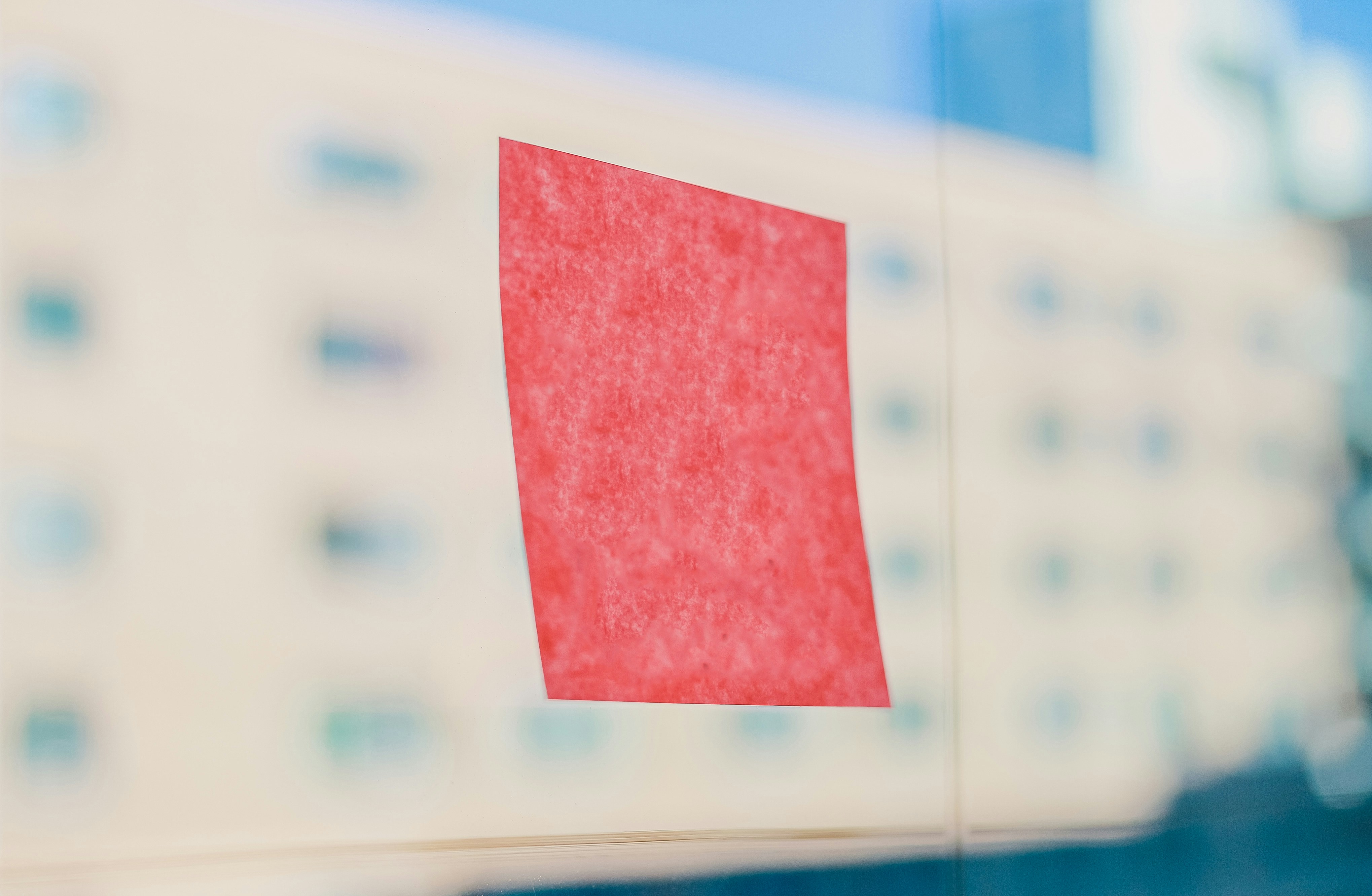 Red sticky note on a window