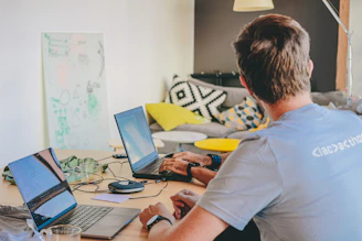 Man working on laptops at a desk.