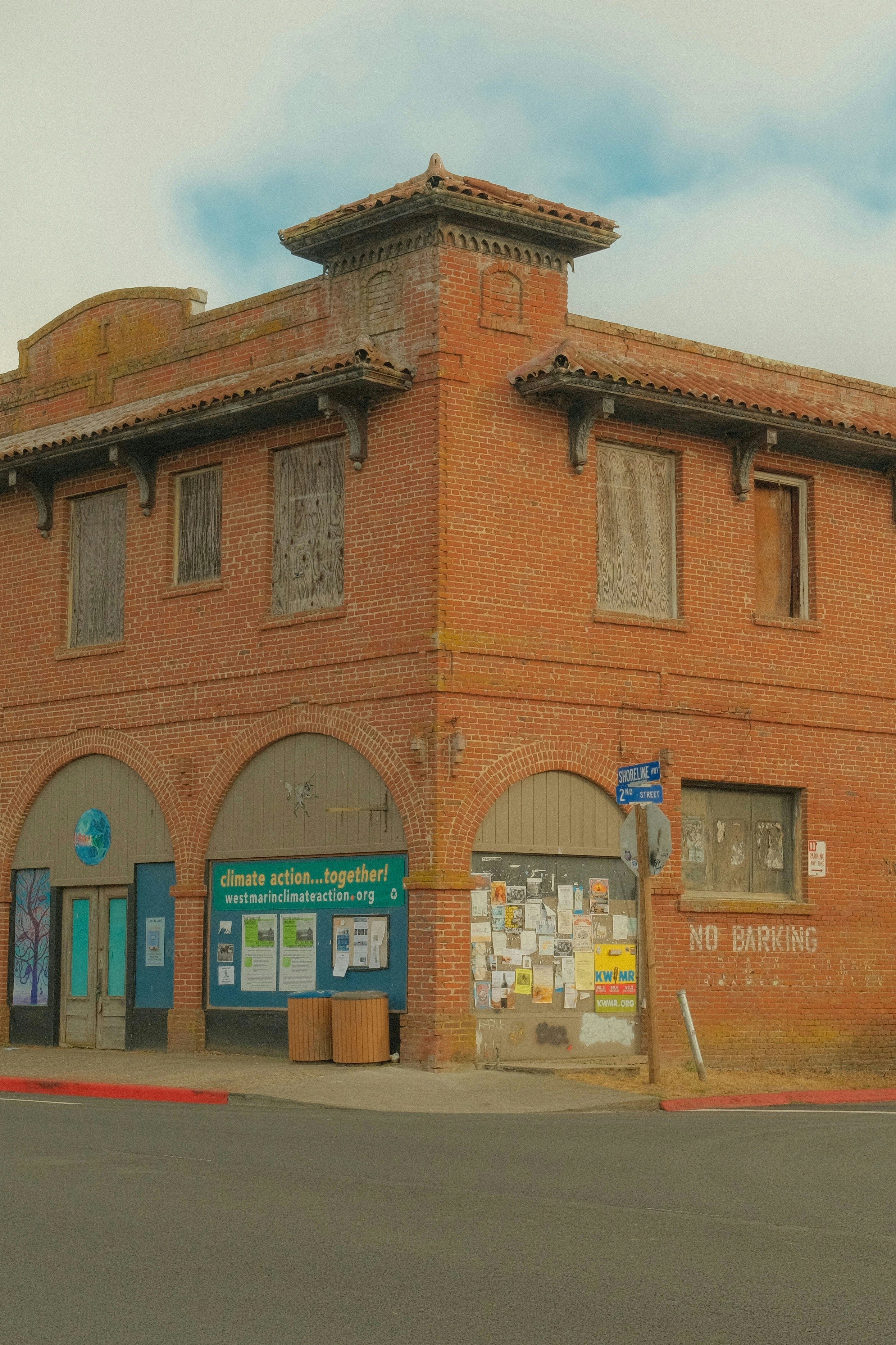 Antiguo edificio de ladrillo con puertas arqueadas y ventanas tapiadas