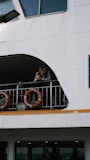 Man leans on railing of a white ferry boat